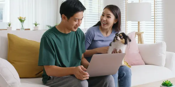 Couple with dog using laptop